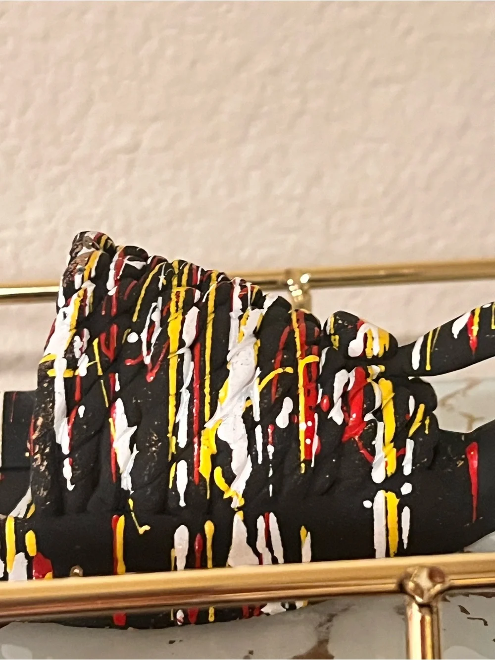 Hand-Painted Black Decorative Shoe Accent with Red, Yellow & White Drip Design